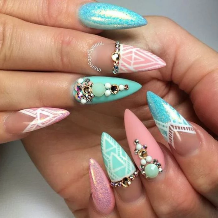 mix of pastel and glossy nail-polish, in white an pink, teal and turquoise, on stiletto acrylic nails, decorated with pearls and rhinestone stickers, and white hand-drawn dectails