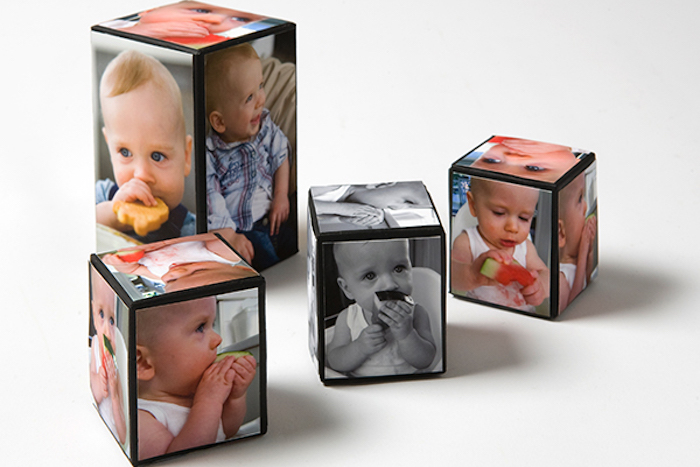 black and white and colored photos of a baby, covering four cube-shaped decorations, in different sizes, mother's day gifts for grandma