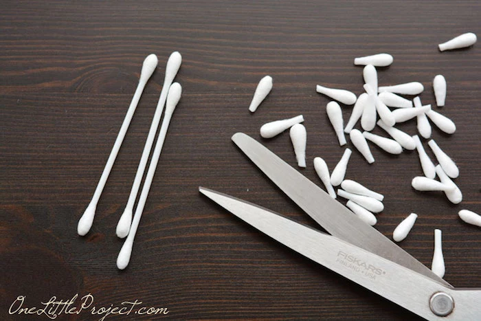 removing the tips, of plain white cotton ear buds, using scissors, easter crafts for kids 