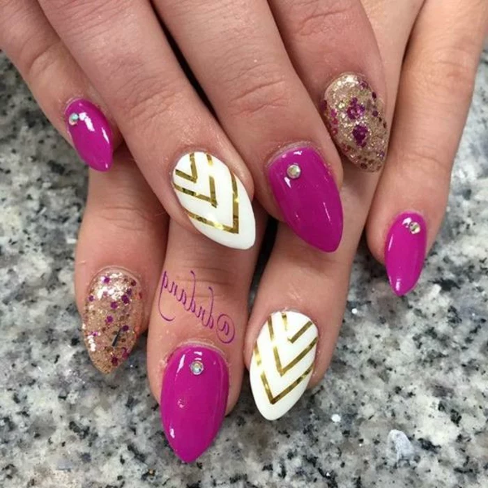 combination of pink-purple, gold and white, on short stiletto nails, with golden stripes and glitter, and small rhinestones