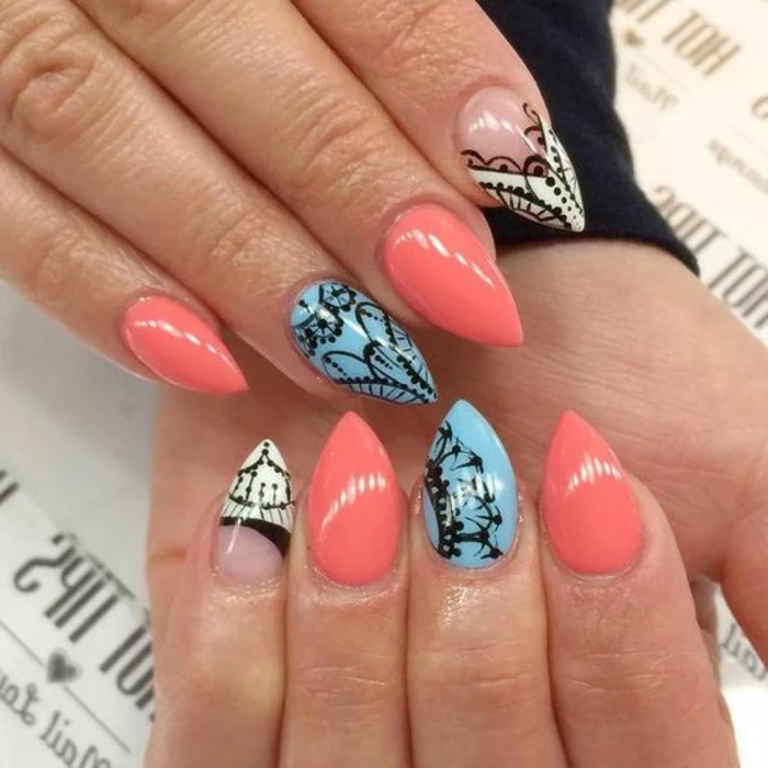 lace-like pattern, hand-drawn in black, on short stiletto nails, in coral pink, light blue and white, and clear nail polish