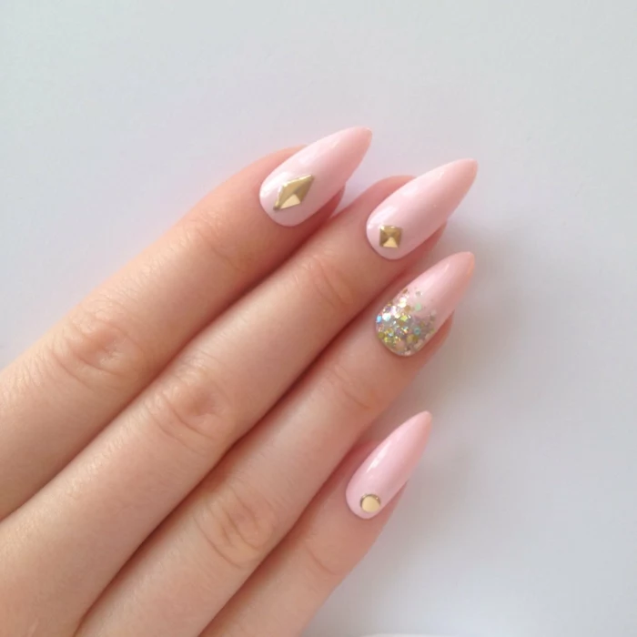 baby pink manicure, with iridescent glitter, and gem nail decals, stilleto nail designs