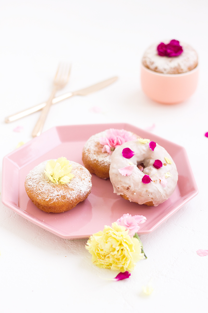 pastries or donuts, some dusted with powdered sugar, and one covered with pink glazing, top 10 mother's day gift ideas, decorated with flower petals
