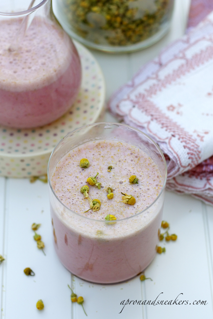 healthy smoothie recipes, pink frothy drink, inside a clear tumbler glass, topped with dried camomile flowers