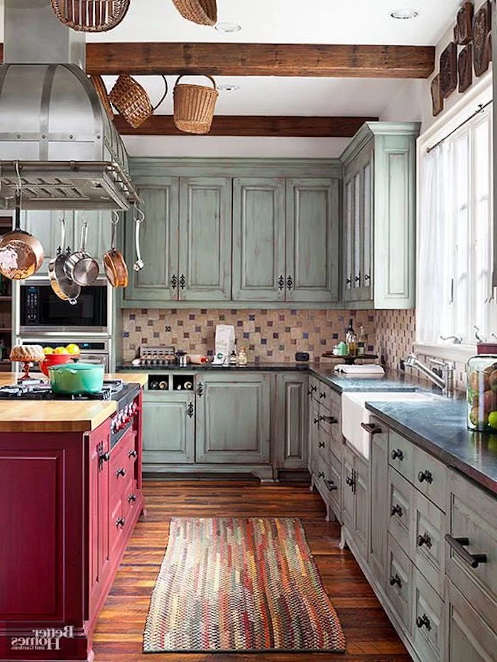 multicolored rug on a wooden laminate floor, inside a shabby chic kitchen, with rustic vintage duck's egg blue cupboards, and a red kitchen island