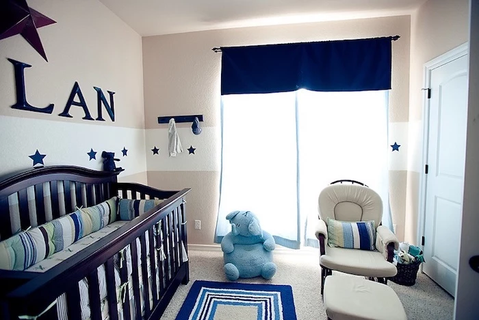 boy nursery, with beige and white walls, with star motifs, dark brown crib, dark navy details, pale blue elephant toy