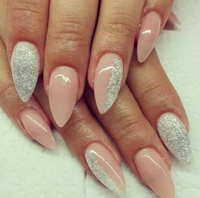 fine silver glitter, on long and pointy nails, covered in pale pastel pink nail polish, sweet and effective look