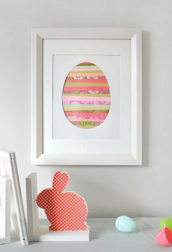 paper art in white frame, easter crafts for adults, colorful egg-shape, made from washi tape strips, in different colors and patterns