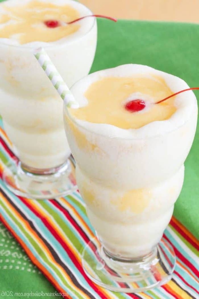 fluffy and frothy drink, in white and yellow, topped with a straw and a maraschino cherry, fruit smoothie recipes, blended pina colada 