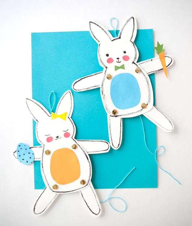male and female easter bunny paper dolls, with movable legs and arms, decorated with colorful paper cutouts