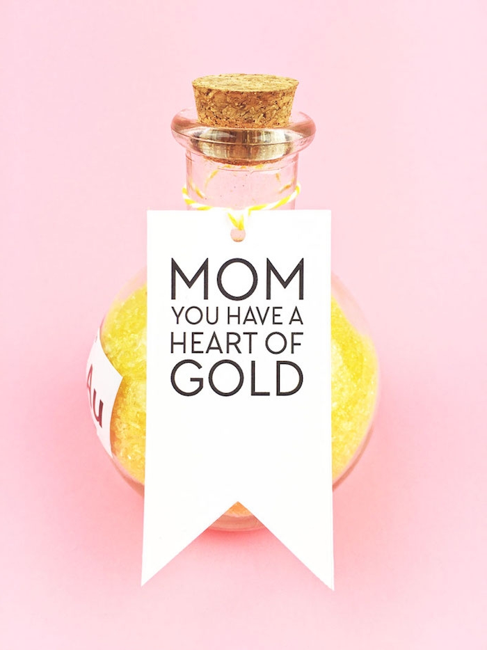 round bottle made of glass, with cork stopper, containing yellow bath salts, mothers day gifts, white label with message to mom