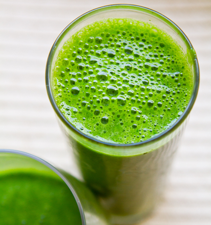 frothy light green, healthy blended drink, green smoothie recipe, inside tall clear glasses, on white background