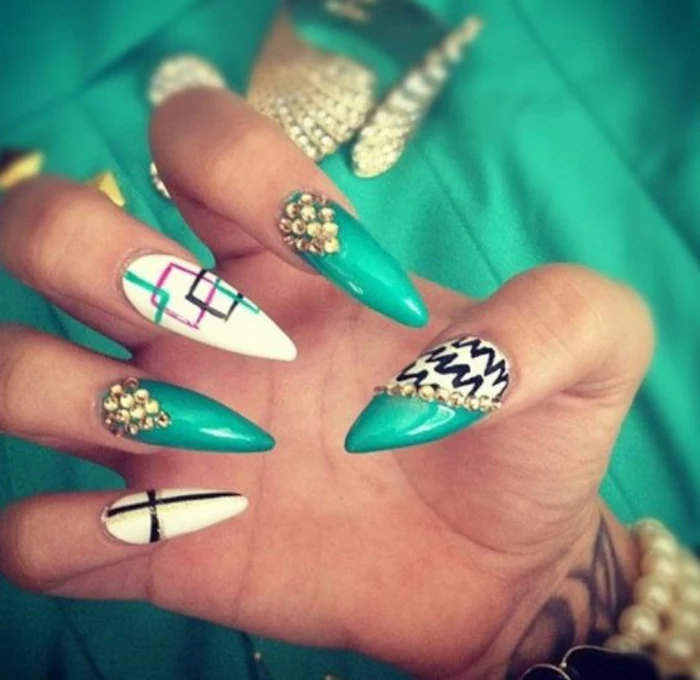 squares outlined in green, pink and black, on white and green long stiletto nails, decorated with hand-drawn scribbles, and little golden rhinestone stickers