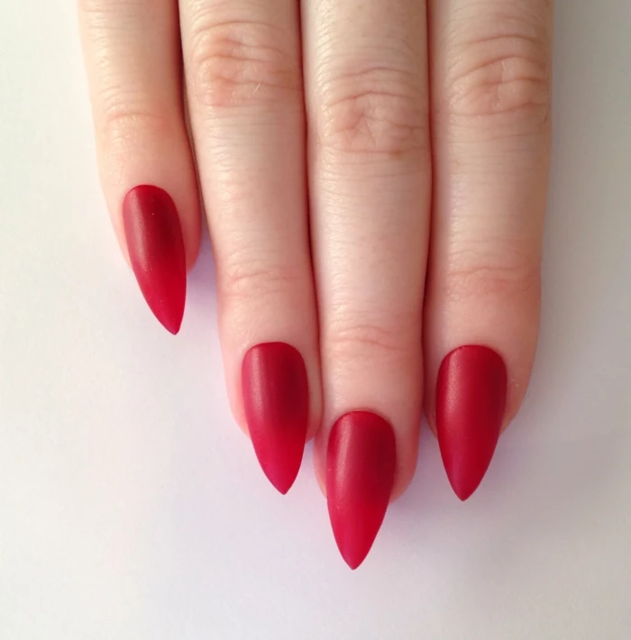 celebrity style manicure, long and sharp nails, painted in matte red nail polish, simple and classy