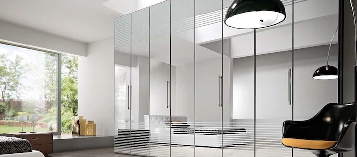 mirror covered closet, large with four or more doors, inside white bedroom, with bed and black modern chair, stylish wardrobes for a brighter home