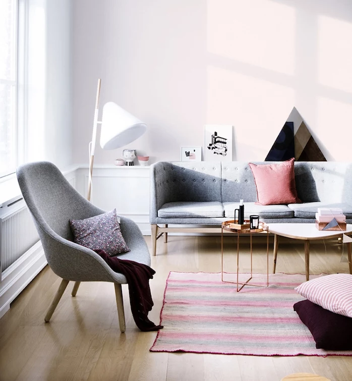 pinkish gray walls, with white paneling, light wooden laminate floor, pale gray sofa and armchair, colors that go with gray walls, striped rug, what colours look good with grey