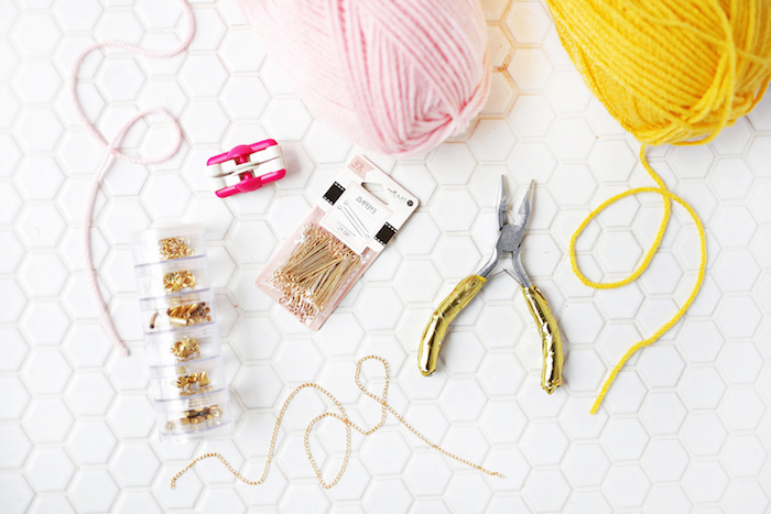 pastel pink and yellow, knitting woolen thread, gift ideas for mom, making a bracelet, near pair of pliers, jewelry making pins, lobster clasps and a thin gold chain