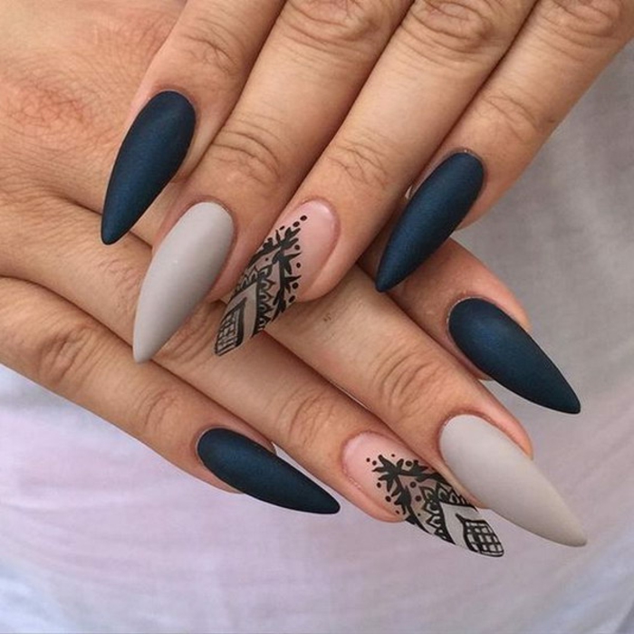 grey clear and black matte nail polish, on long stiletto nails, with black hand-painted decorations
