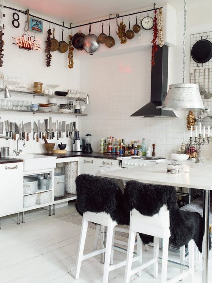 collection of cooking knives, inside room with white tiled walls, country kitchen decorating ideas, modern white table and matching chairs