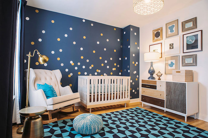 yellow and white dots, on navy blue wall, inside boy nursery, with white wooden crib, and rocking armchair