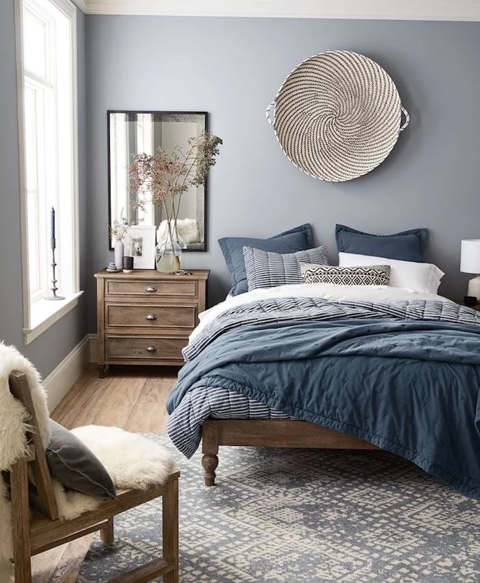 blue grey paint, in nordic style bedroom, bed covers in different shades of blue, wooden floors and furniture