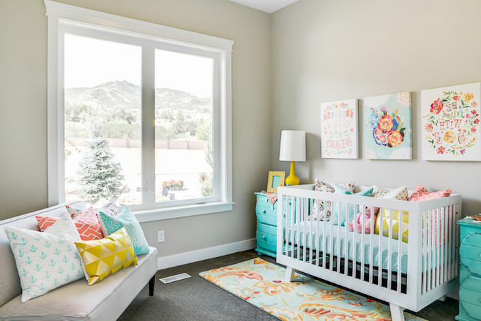 turquoise cupboards near white wooden crib, baby nursery ideas, off-white sofa, three multicolored canvases, many cushions in various colors and patterns, baby nursery ideas
