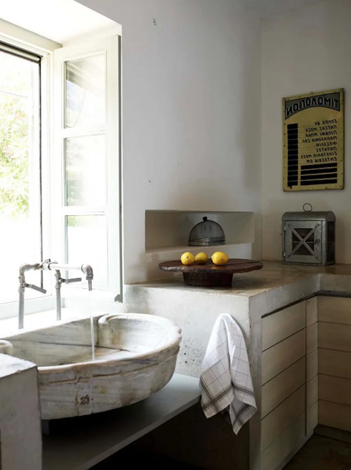 antique sink and metal tap, rustic country home décor, inside a room with industrial-style cupboards, vintage poster and metal breadbox, three lemons on a wooden dish