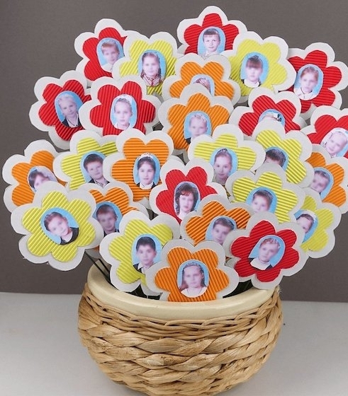 lots of flowers, made from red and orange, yellow and white paper, with wire stalks, and photos of kids and adults, mother's day gifts for grandma, inside wicker basket