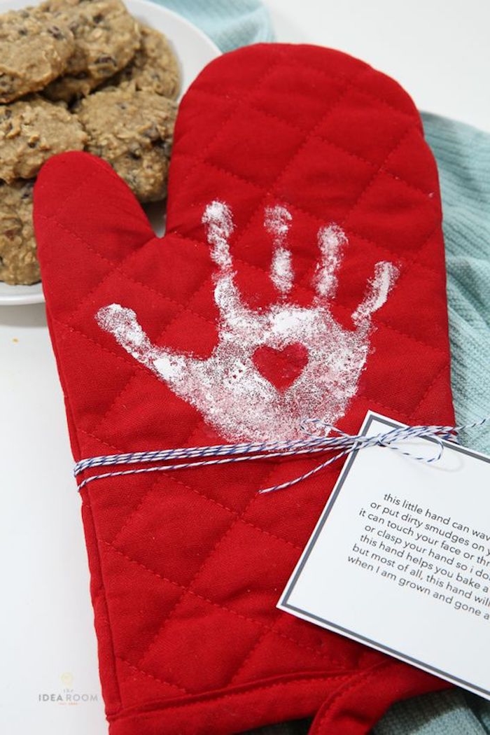 print of a small child's hand, with a little heart detail, on red oven mit, with thread and white label, mother's day gifts for grandma