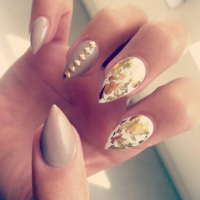 gold leaf and golden nail decals, on sharp and short stiletto nails, painted in grey and white nail polish