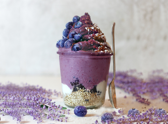 healthy breakfast smoothies, creamy parfait made from creamed, purple sweet potatoes, and mashed blueberries, inside a clear glass glass, with quinoa and yoghurt
