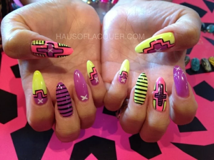eighties or nineties style, retro manicure in neon colors, with stripes and crosses, and asymmetrical shapes, on long stiletto nails 