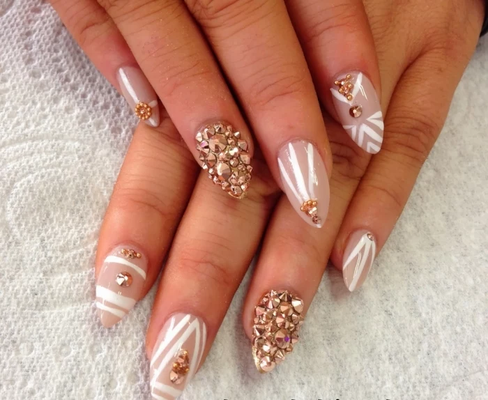 rose gold rhinestone nail decals, on beige-pink colored sharp nails, decorated with white stripes