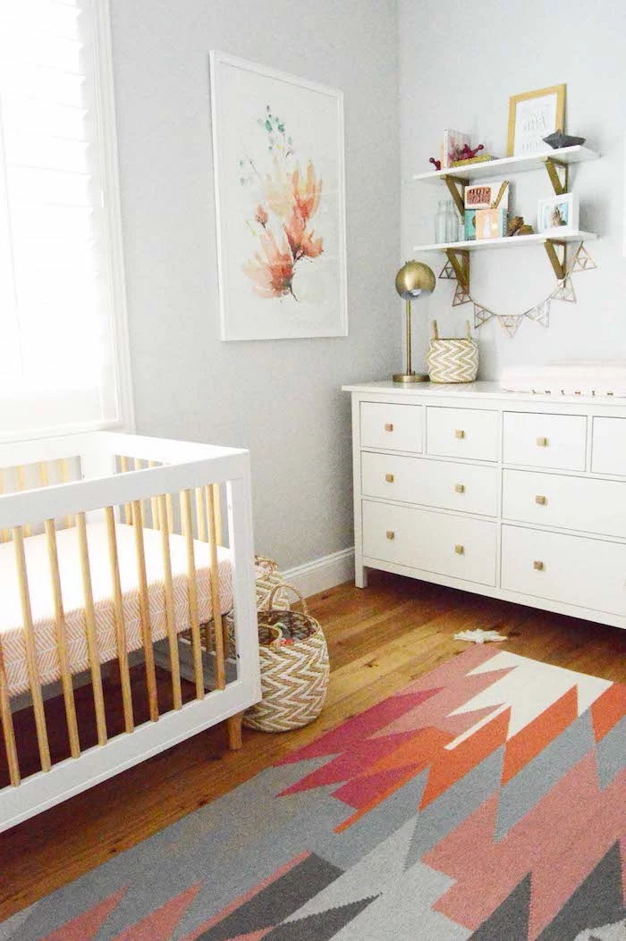 retro-inspired nursery ideas, white wooden crib, with beige details, matching chest of drawers, wooden laminate floor, and multicolored modern rug