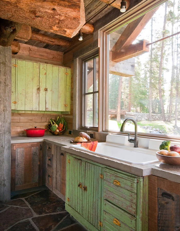 big window near a large sink, with antique metal tap, country kitchen decorating ideas, shabby green cabinets, and a stone floor 
