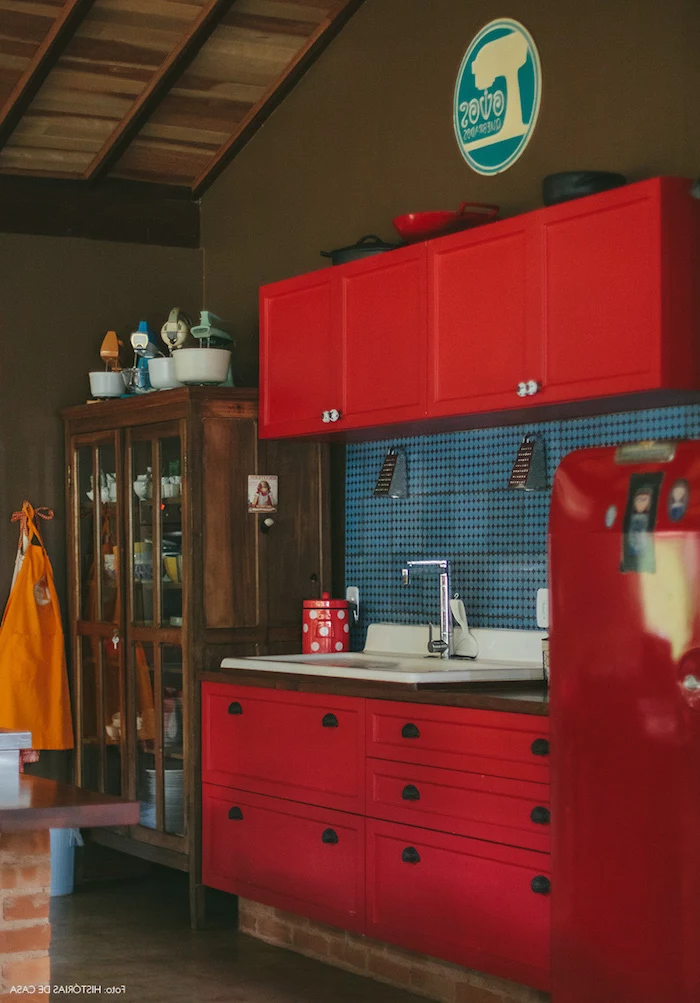 red country kitchen cabinets, near vintage dark brown wooden cupboard, in room with brown walls and floor