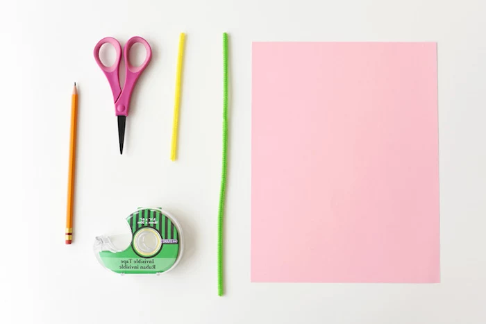 plain pencil and small pink scissors, green and yellow fuzzy wire, easter diy, sticky tape dispenser, sheet of pastel pink card