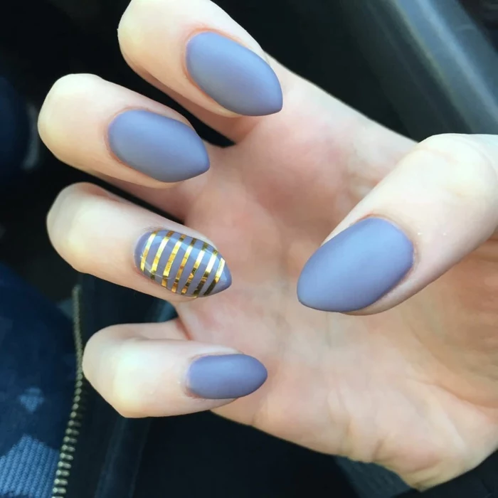 golden metallic stripes, on short but sharp stiletto nails, painted in grey, matte nail polish
