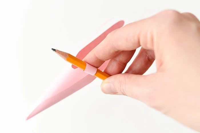 curling the folded, hand-shaped piece of paper, using a plain pencil, easter diy, fun activity for kids