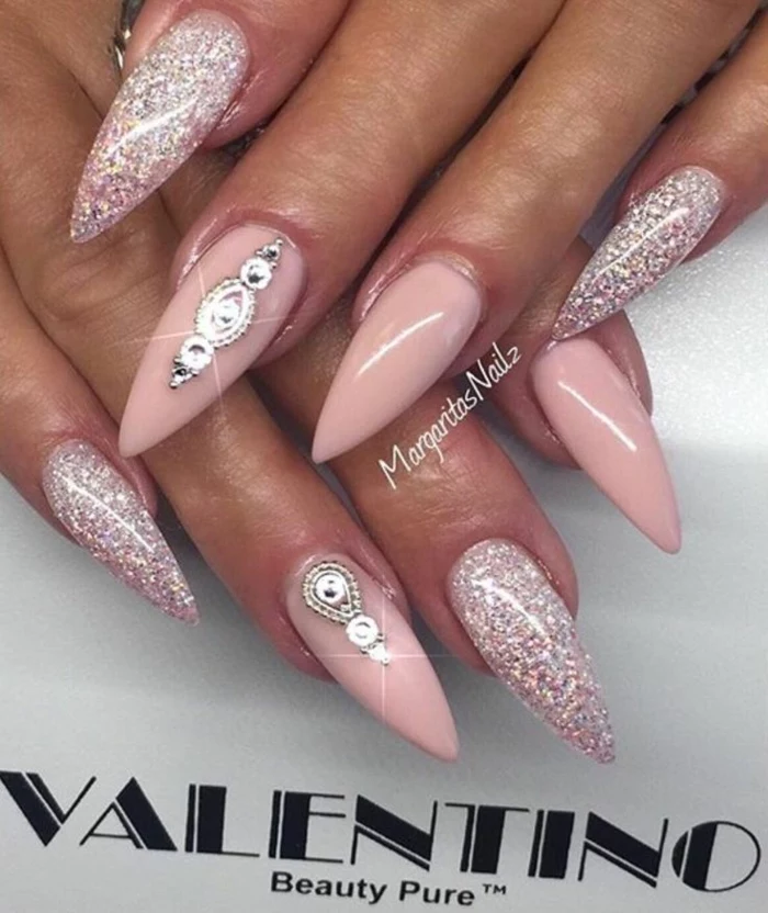 valentino long stiletto nails, with pink and silver glitter, and pastel pink nail polish, decorated with silver stickers
