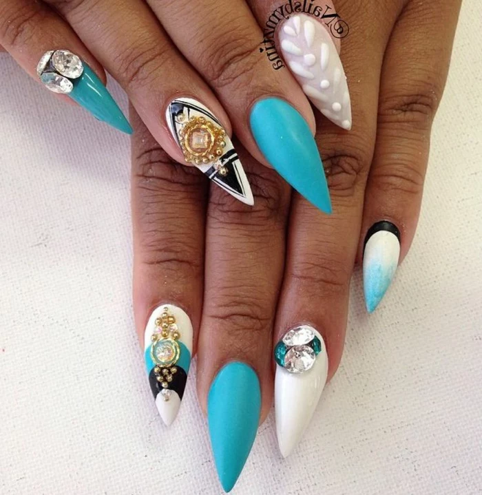 turquoise and white, long and sharp nails, decorated with black details, and gold and rhinestone nail decals