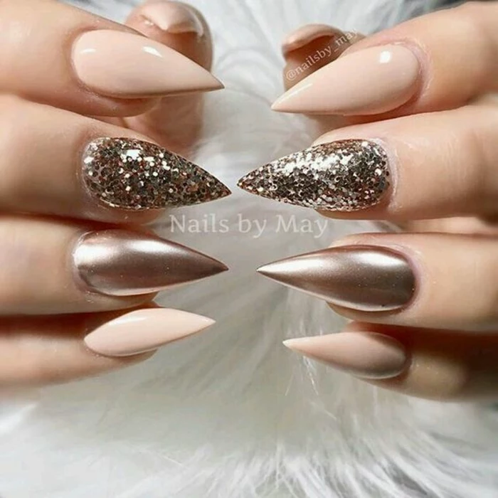 very sharp and pointed, pale pink nails, decorated with rose gold metallic effect, and sparkly glitter