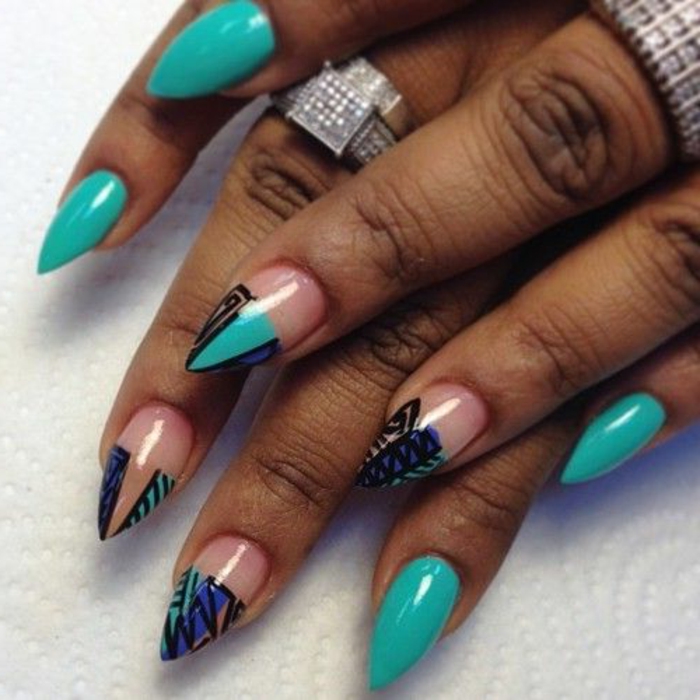 clear nail polish details, on short stiletto nails, painted in turquoise, and decorated with black, hand-drawn ornaments, and pink and blue stripes