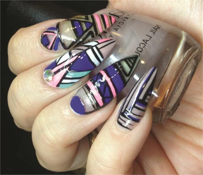 abstract shapes in dark violet, light pink, black and teal, with a single rhinestone sticker, on clear claw nails