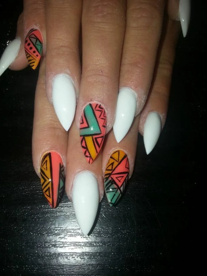 tribal motives in turquoise, yellow and pink, on sharp nails, with opaque white nail polish