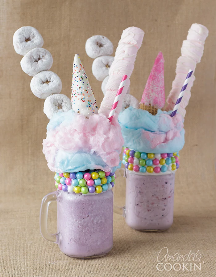 mini donuts and marshmallows, pale pink and blue cotton candy, wafer cone with icing and sprinkles, multicolored candies and straws, decorating purple blended, unicorn-inspired drink