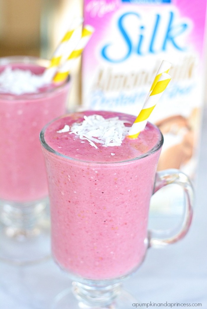 classical strawberry blended drink, decorated with coconut flakes and straws, easy smoothie recipes, in glass with handle