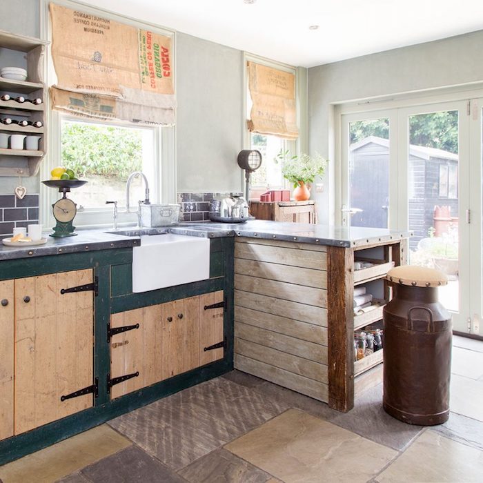 bright room with glass doors, pale gray walls, beige and dark green, vintage country kitchen cabinets, various rustic decorations 