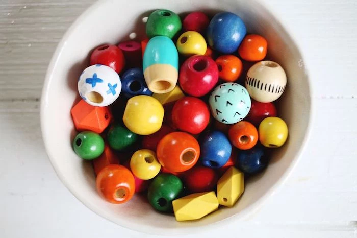 lots of wooden beads, in different shapes and sizes, inside a white ceramic bowl, mothers day gifts, necklace materials