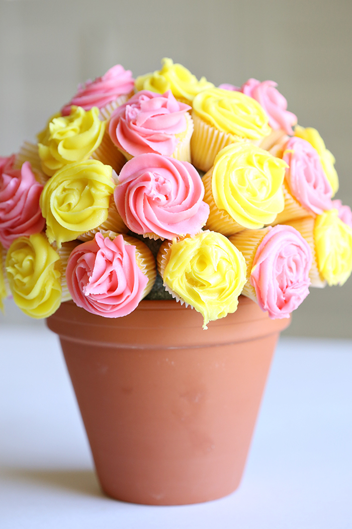 bouquet made from cupcakes, in yellow and pink, top 10 mother's day gift ideas, placed inside ceramic pot, in brownish-orange